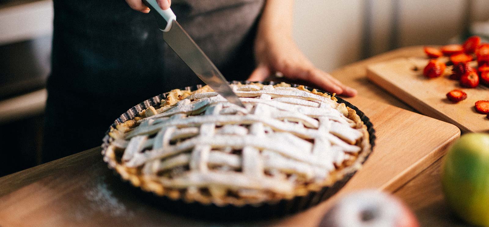 A lady slicing a fresh pie