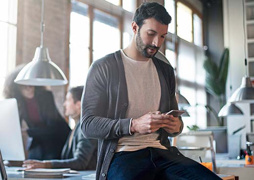 A man using a smartphone in an office